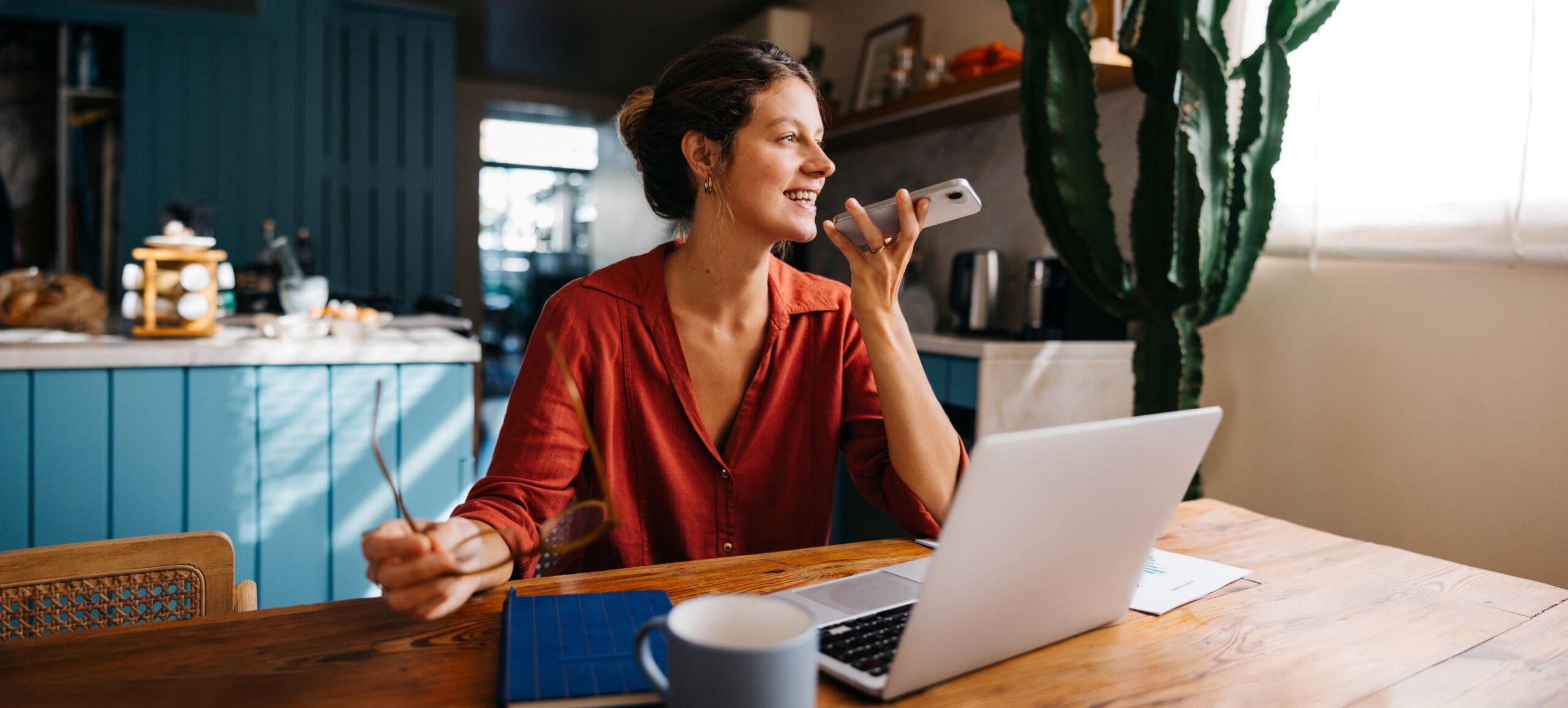 A woman works at a laptop and speaks on her phone from her kitchen, reflecting the everyday human judgment behind research quality.